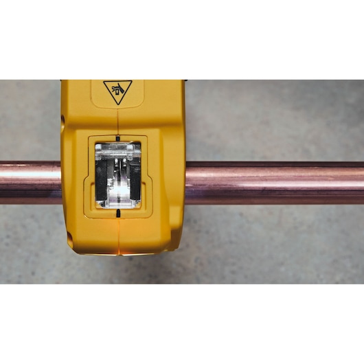 Close-up image of a yellow DEWALT tool clamped around a copper pipe, showing the cutting mechanism.