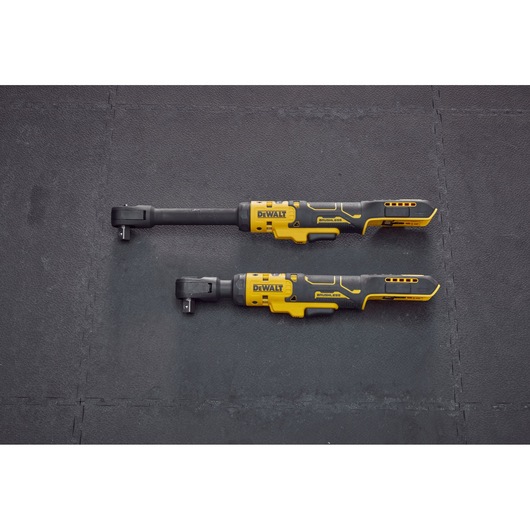 Two DEWALT cordless ratchet wrenches, one with an extended neck and one with a standard neck, are shown side by side on a black textured surface.