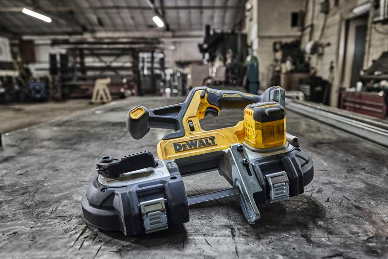 Sega a nastro DEWALT senza fili su banco da lavoro in officina industriale.