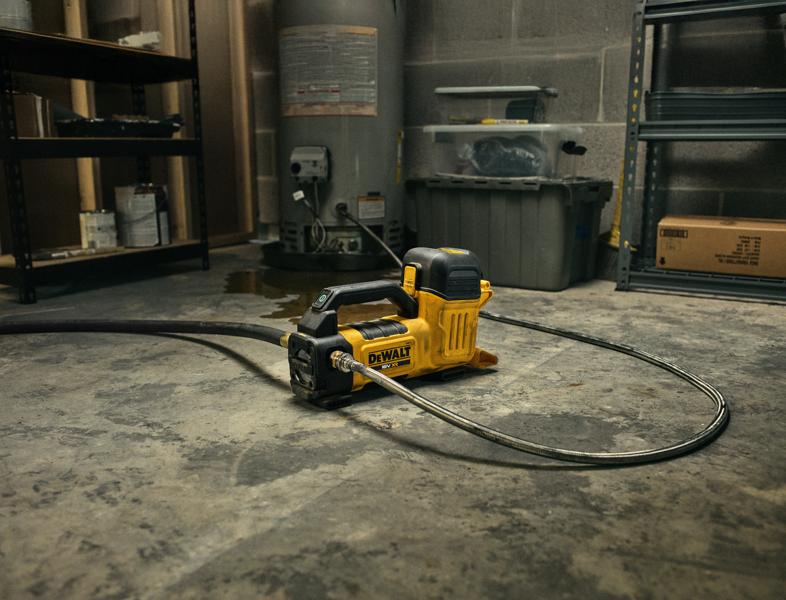 DEWALT DCE050N fotografia categoria attrezzo su pavimento, collegato a tubo, tra scaffali.